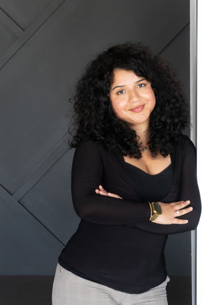 Professional portrait of Dulce Diaz, Central Florida real estate professional, smiling against a modern dark geometric background.